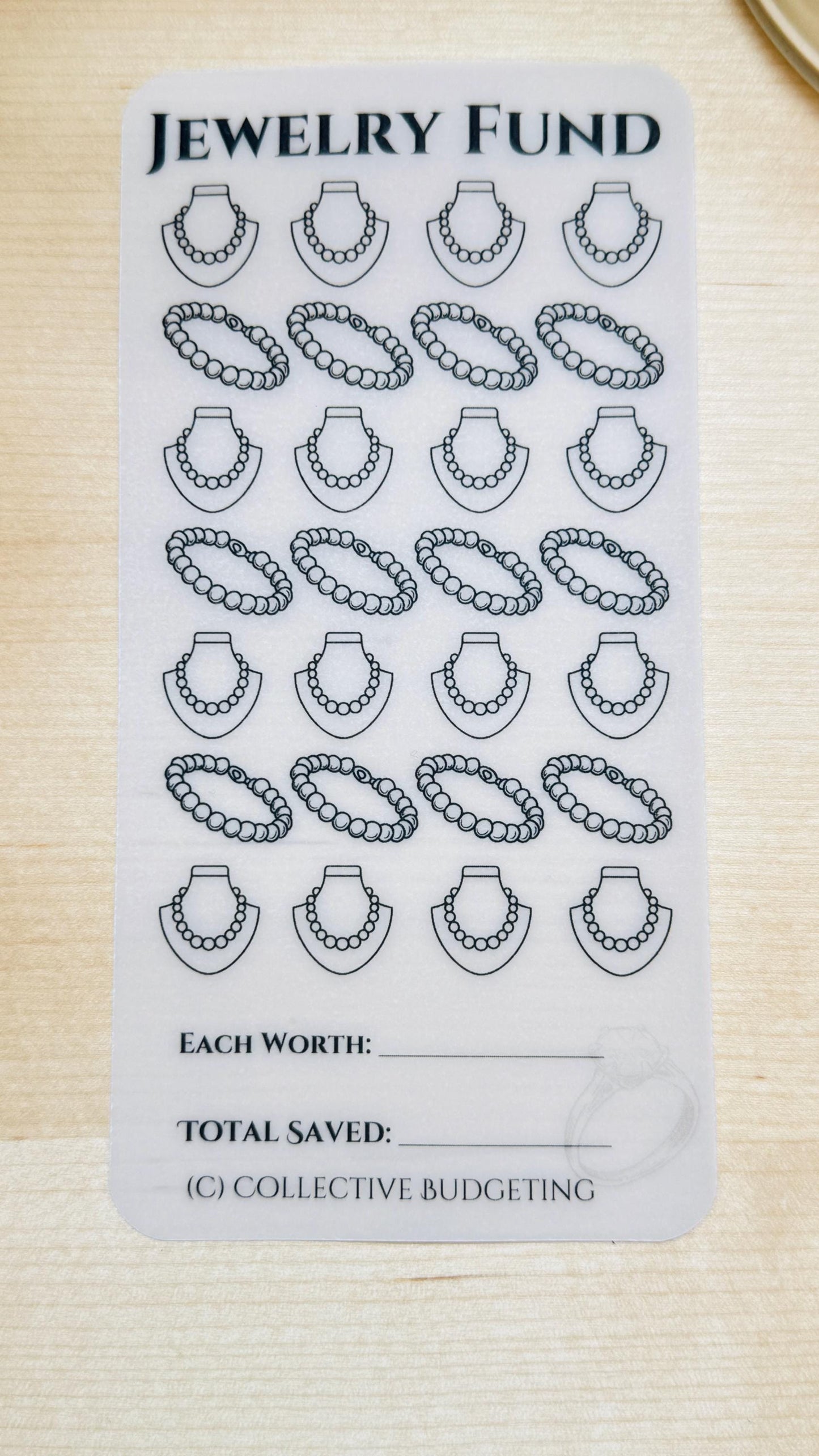 1 clear plastic sheets with a black and white jewelry design. The sheets have text that reads 'JEWELRY FUND', 'EACH WORTH', 'TOTAL SAVED', and '(C) COLLECTIVE BUDGETING'.