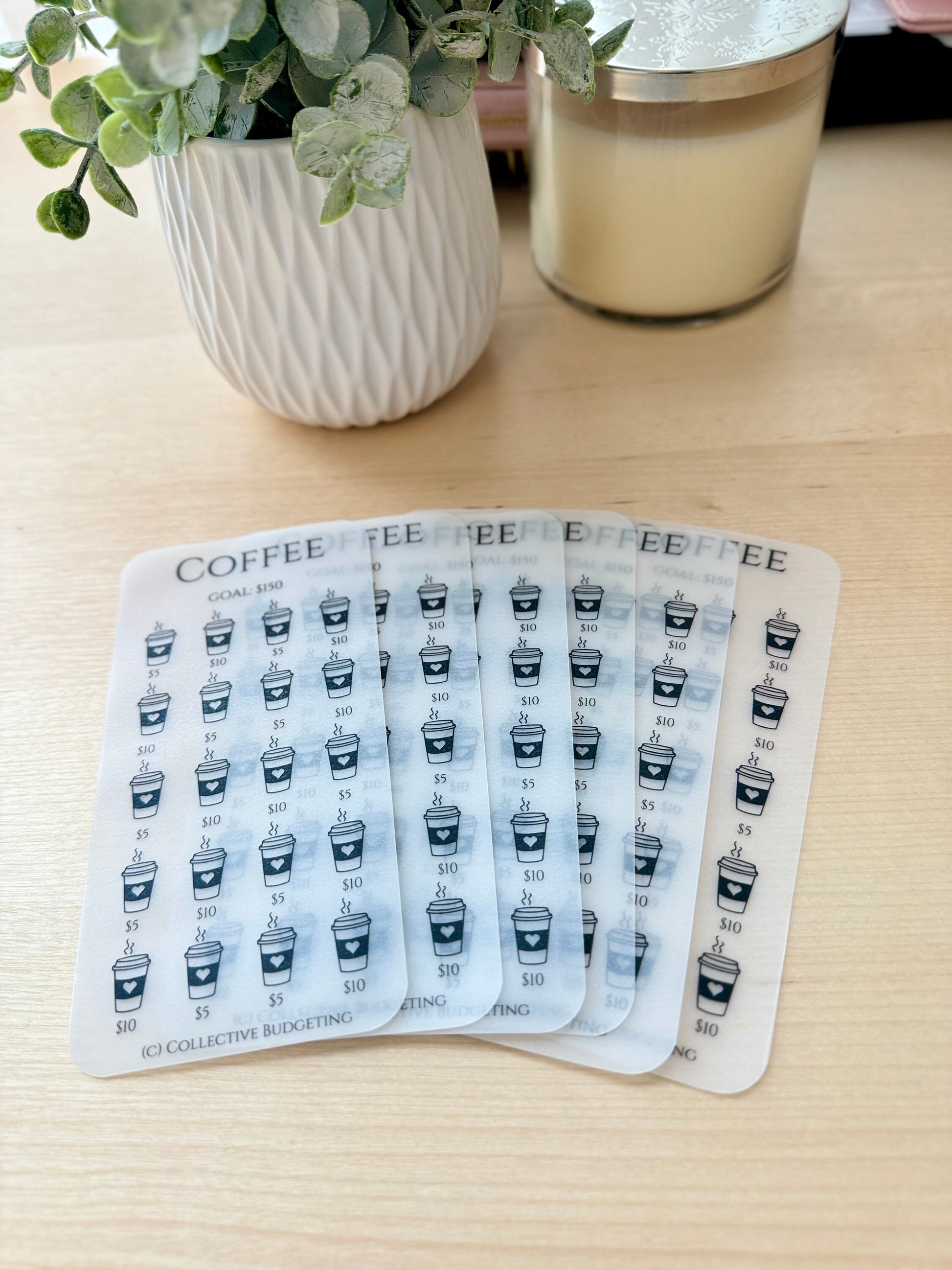 Six transparent sheets with a coffee cup design and the words 'COFFEE' and 'GOAL: $150'. Each sheet has a grid of coffee cups with dollar amounts of $5 and $10. The bottom of each sheet has the text '(C) COLLECTIVE BUDGETING'.
