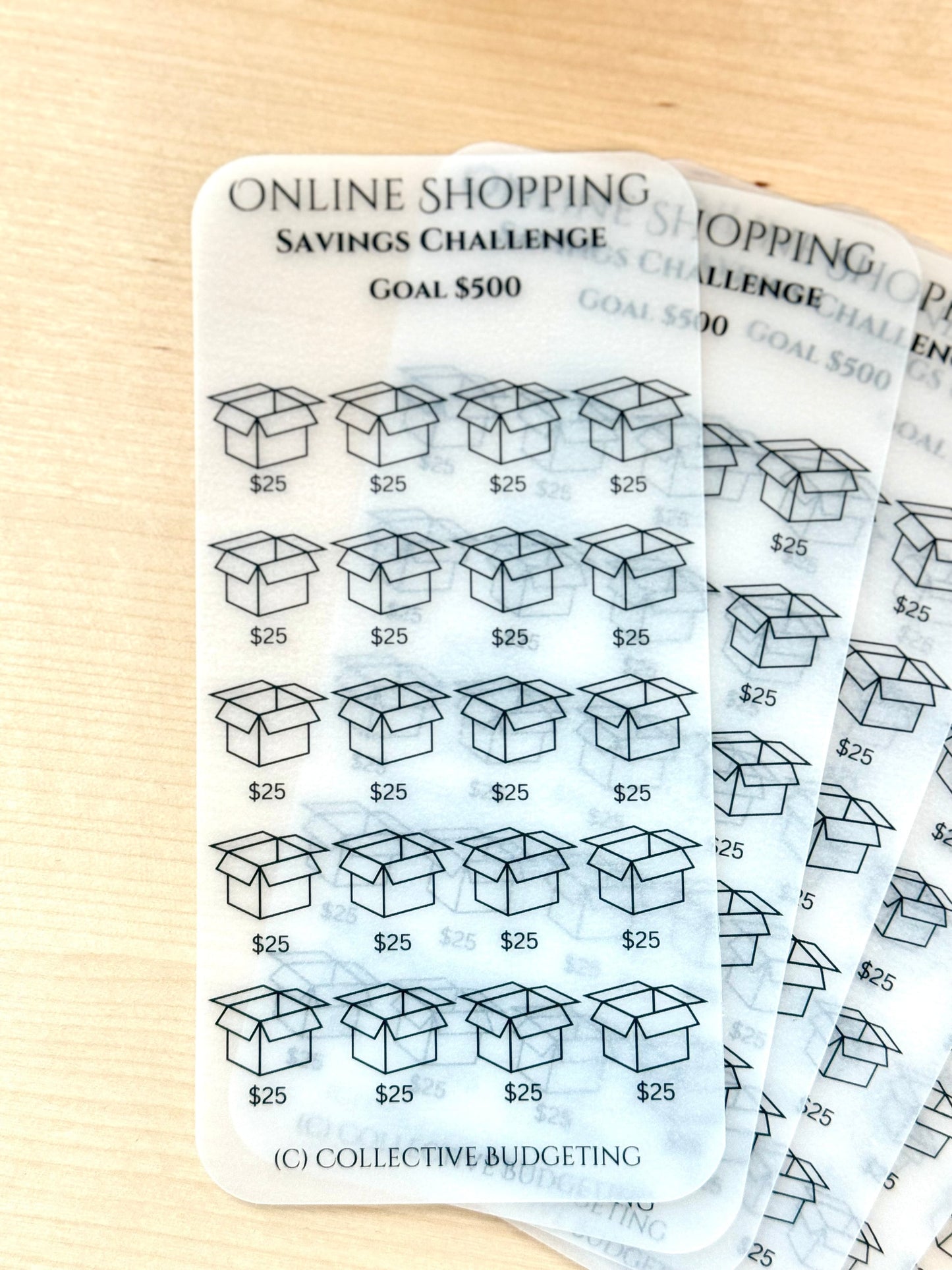 A set of 20 transparent cards with a black outline of a box and the text '$25' printed on each card. The cards are stacked on top of each other, and the text 'ONLINE SHOPPING SAVINGS CHALLENGE GOAL $500' is printed at the top of the cards. The text '(C) COLLECTIVE BUDGETING' is printed at the bottom of the cards.