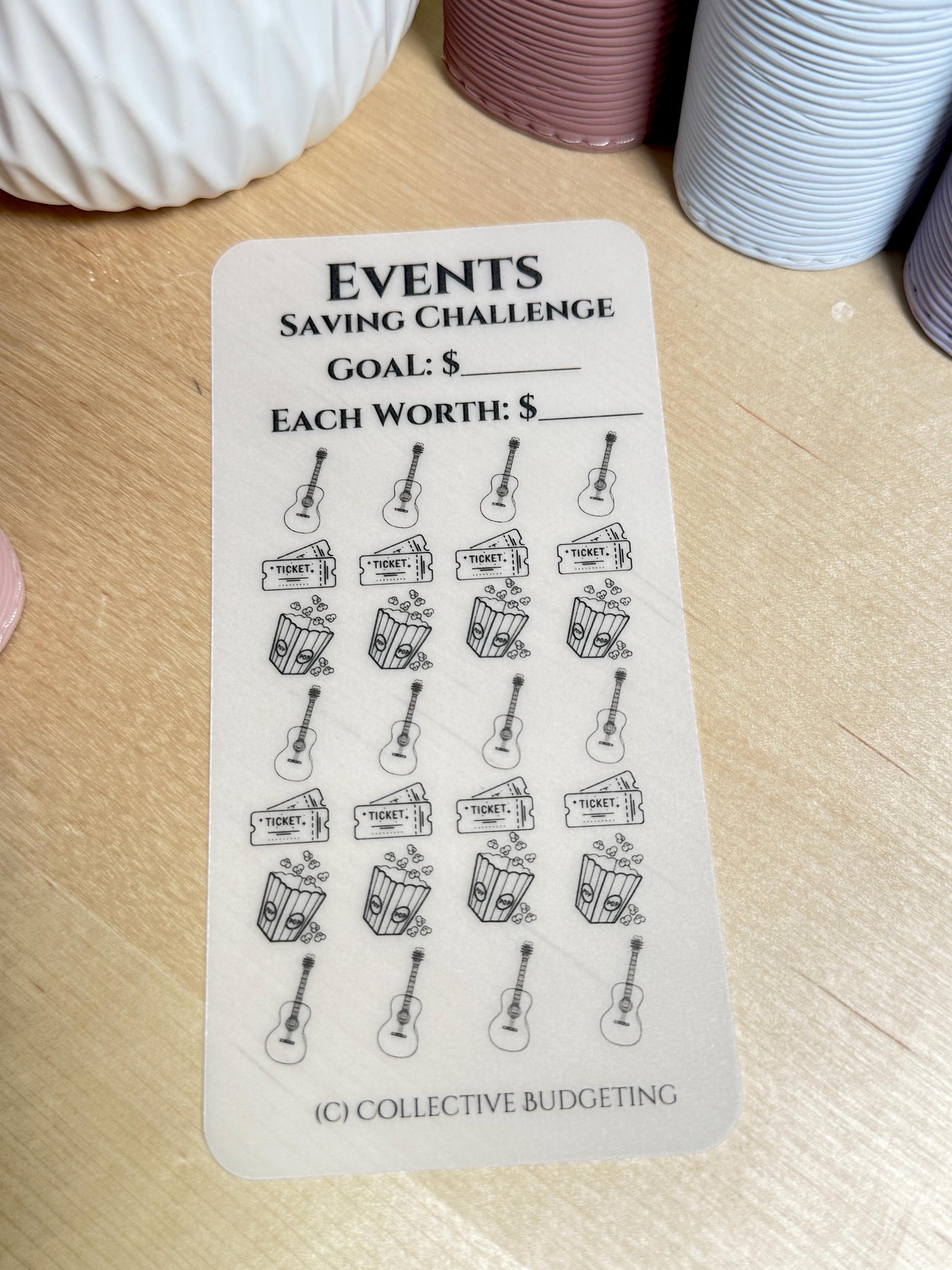 A white sticker sheet with black text and illustrations. The text reads 'EVENTS SAVING CHALLENGE GOAL: $ EACH WORTH: $'. The sticker sheet has 18 stickers, each with a black and white illustration of a guitar, a ticket, and a bucket of popcorn. The bottom of the sticker sheet has the text '(C) COLLECTIVE BUDGETING'.