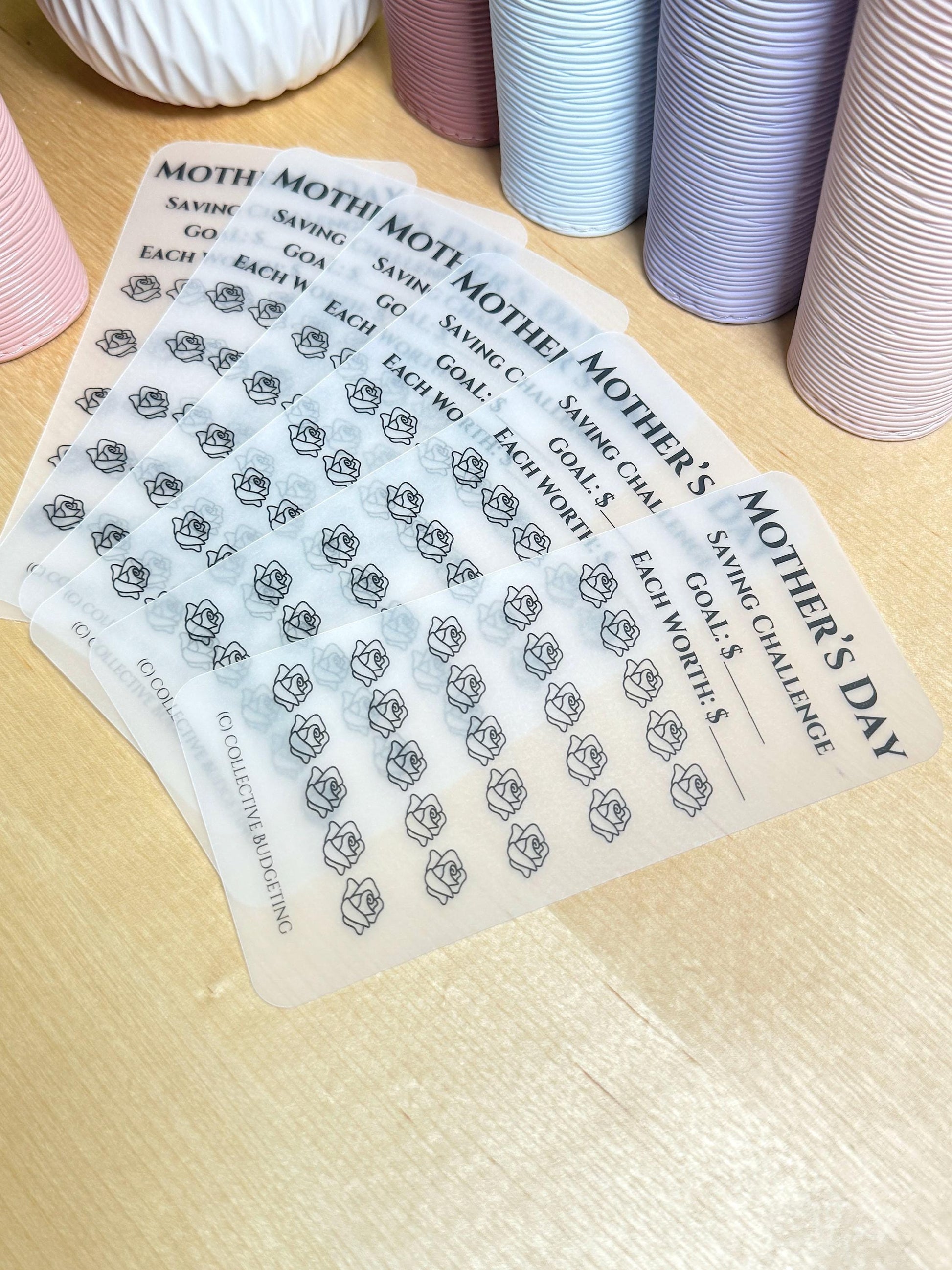 Six clear sheets with black text and rose outlines. The text reads 'Mother's Day Saving Challenge Goal: $ Each Worth: $ (c) Collective Budgeting'.