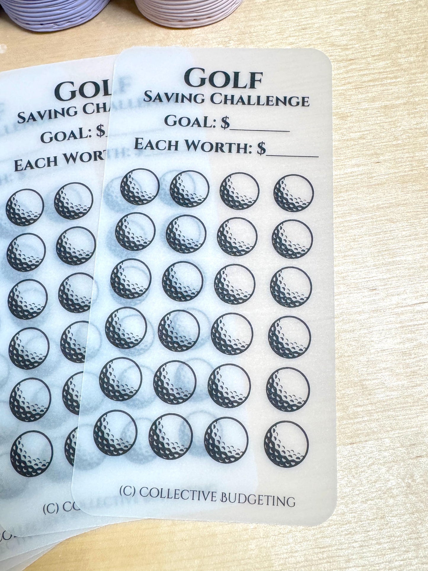 Two white printed laminate golf saving challenge cards. Each card has a black title 'GOLF SAVING CHALLENGE', a blank space for a goal amount, a blank space for the value of each golf ball, and 36 golf ball images.