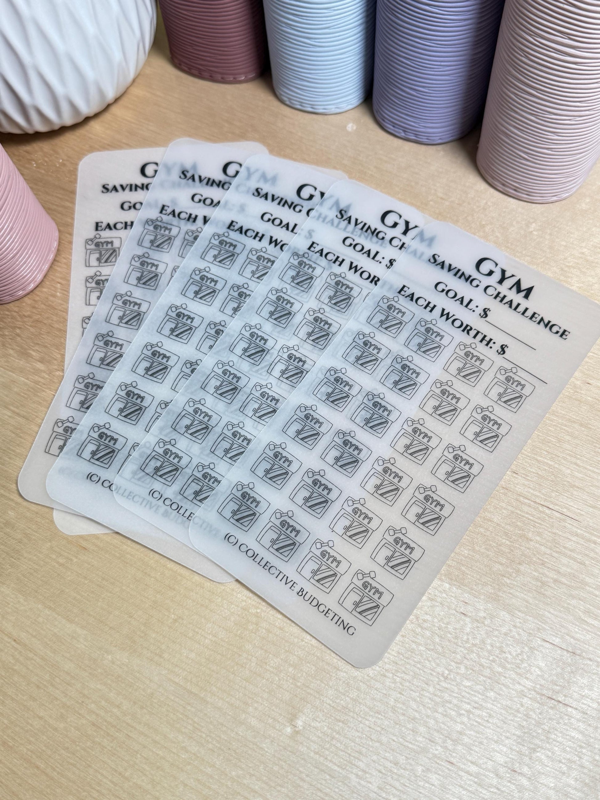 Four sheets of clear savings challenge with black ink. Each sheet has a grid of 36 stickers with a small gym icon on each sticker. The text on the stickers reads 'Gym Saving Challenge', 'Goals: $', 'Each Worth: $', and '(C) Collective Budgeting'.