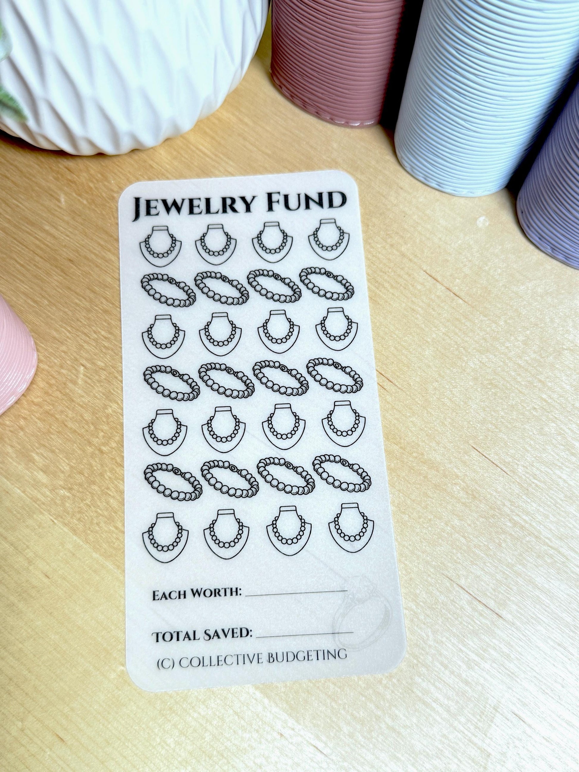 A white sticker with black text and images. The text reads 'Jewelry Fund', 'Each Worth', 'Total Saved', and '(C) Collective Budgeting'. The sticker has 20 images of necklaces with beads on them.