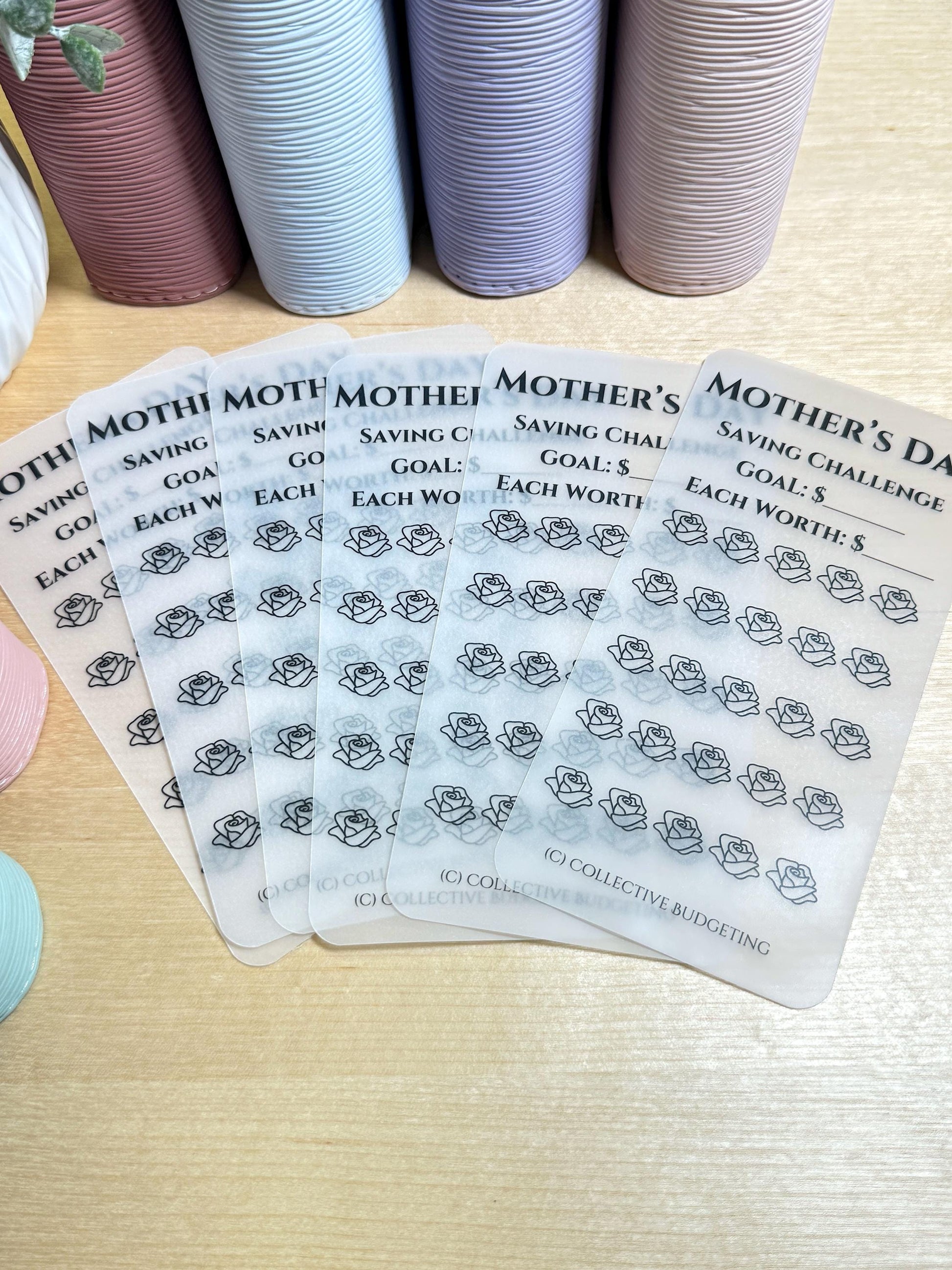 Six transparent sheets with black text and rose outlines. The text reads 'Mother's Day Saving Challenge Goal: $ Each Worth: $'. The text is repeated on each sheet with a different number of roses. The bottom sheet has the text '(C) Collective Budgeting'.