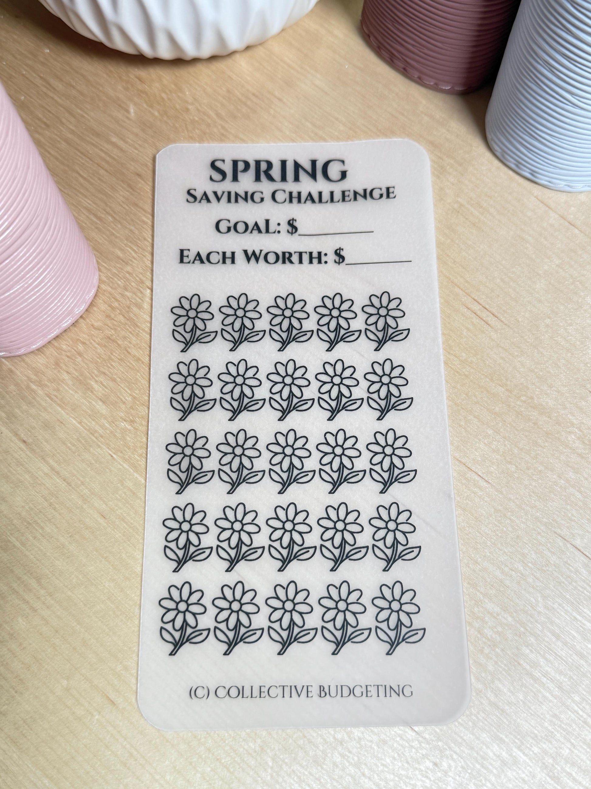 A white printable spring saving challenge tracker with black text. The text reads 'SPRING SAVING CHALLENGE', 'GOAL: $', 'EACH WORTH: $'. There are 36 black and white flower icons on the tracker. The bottom of the tracker reads '(C) COLLECTIVE BUDGETING'.