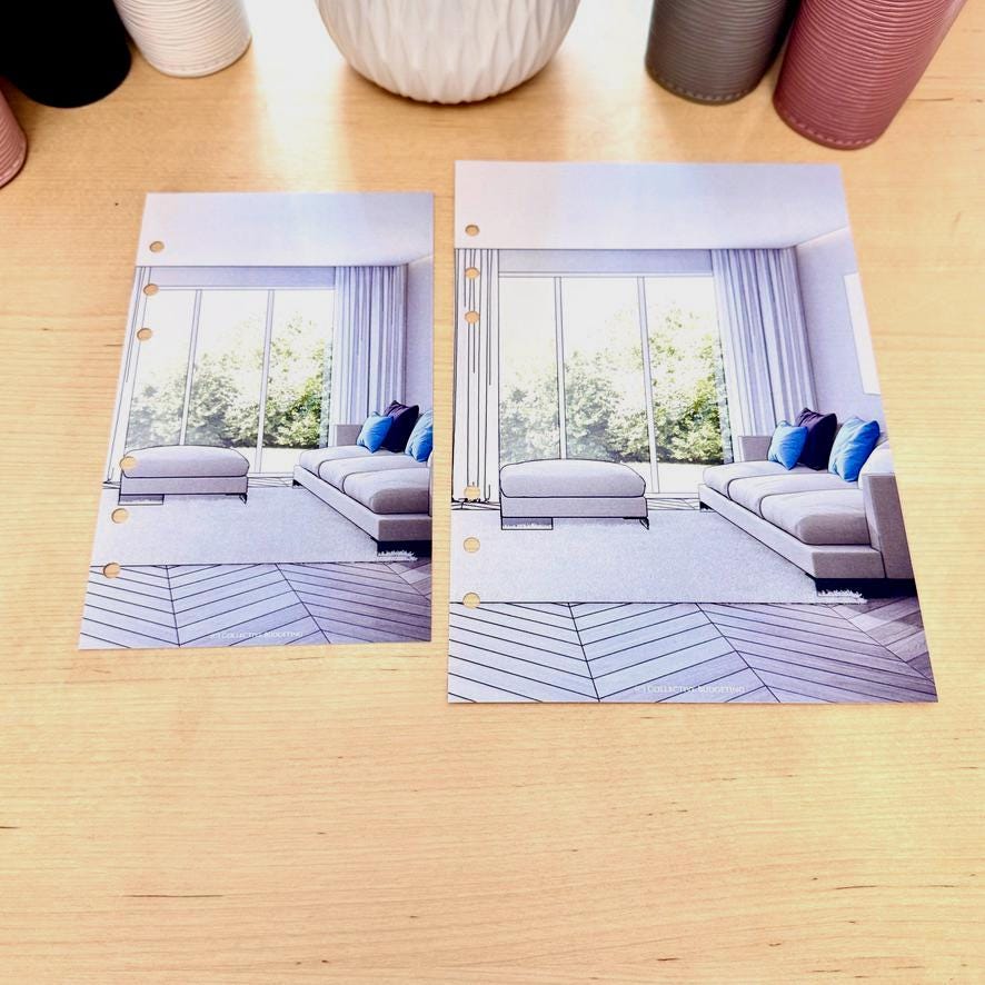 Two printed planner pages with a light blue background and a white and gray interior design scene. The scene includes a couch, two ottomans, and a large window with a view of trees. The pages have a row of holes on the left side for a binder.