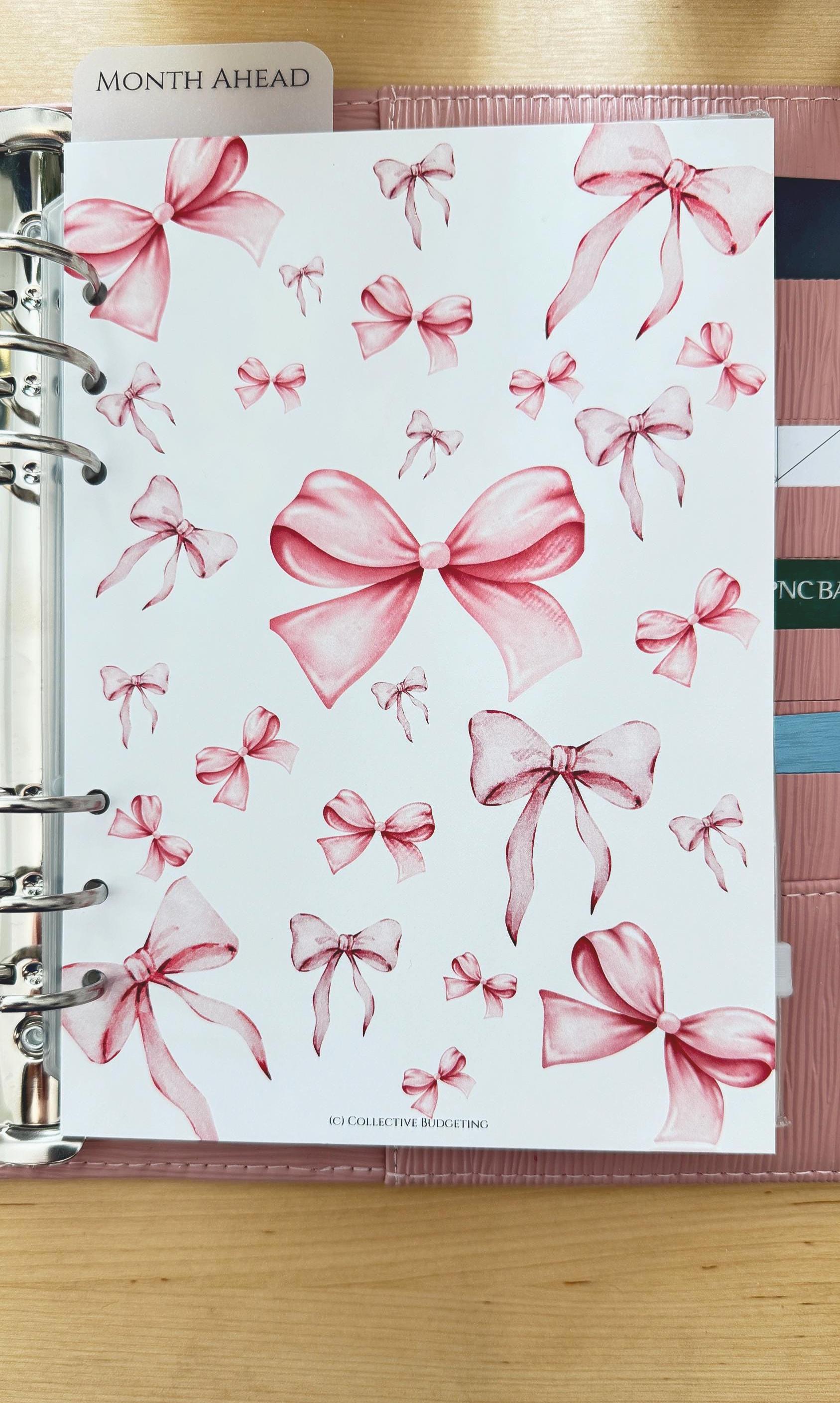 A white planner page with pink watercolor bows scattered across the page. The page has the text 'MONTH AHEAD' at the top and 'IC COLLECTIVE BUDGETING' at the bottom.